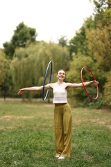 Athletic young woman exercising with hula hoops in park © New Africa