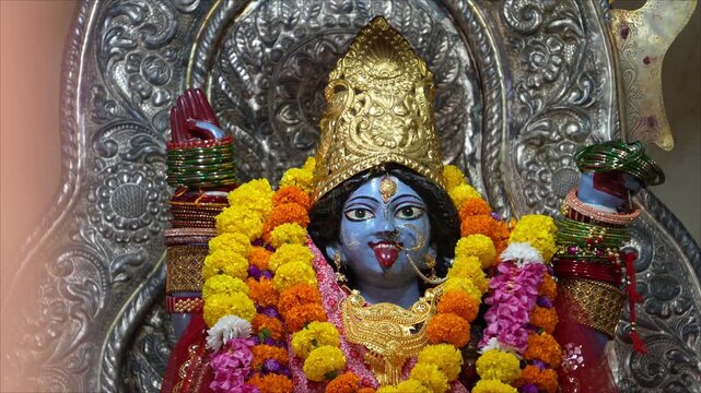 Goddess Kali idol with blue face decorated with marigold flower garlands during Kali Puja festival