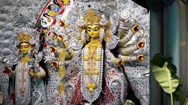 Ornate multi-armed Maa Durga idol with intricate jewelry and weapons at festival pandal, close-up
