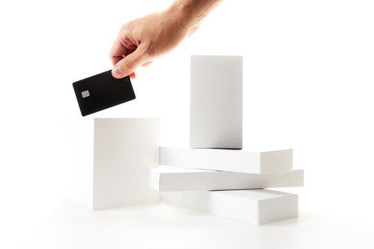 Hand holding black credit card with minimalist white product boxes mockup Black Friday