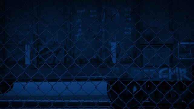 Train Carriages Passing Behind Fence At Night