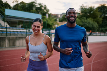 Obraz premium Diverse couple running together on stadium track
