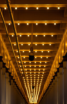 Rows of lights in a tunnel with security cameras hanging from the ceiling 