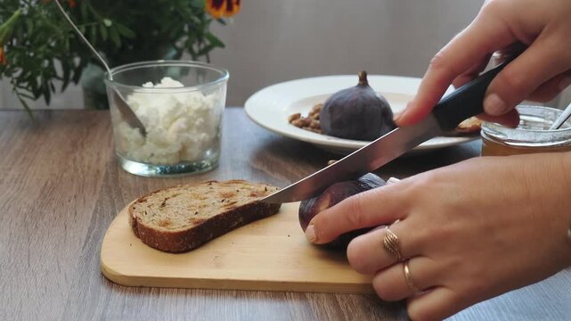 Toasted whole wheat bread with figs, ricotta (cream cheese),mint, honey served on white wooden cutting board. Healthy food concept.