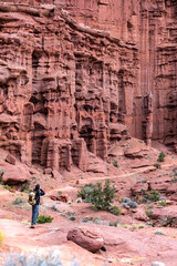 Hiker Photographing sandstone wall of Echo Tower in the Fisher Towers near Moab, Utah, USA © Katrin