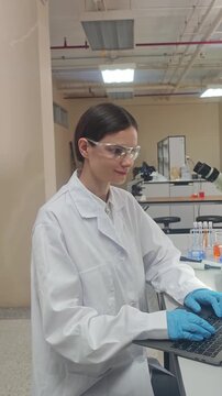 Lab or laboratory. Female scientist conducting laboratory research using lab tools. Such as microscope pipette and laptop to analyze samples and colorful bio chemical solutions in a modern laboratory