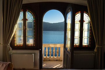 Fototapeta premium Lake View Through Open Door and Stained Glass Windows in Austria