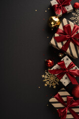Obraz premium Merry Christmas and Happy New Year luxury gifts with red ribbon and gold ornament on black vertical elegant background