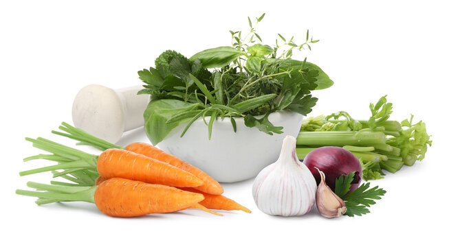Carrots, celery stalks, onion, garlic and mix of herbs on white background