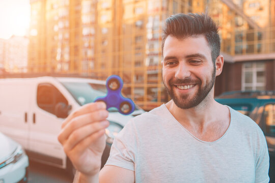 Young man holding and playing with fidget spinner