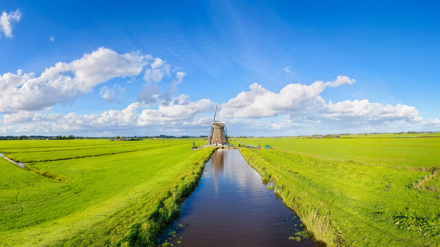 Aerial drone view of traditional windmills in the Netherlands. Panoramic view. Green fields and rural countryside landscape in the Dutch region.