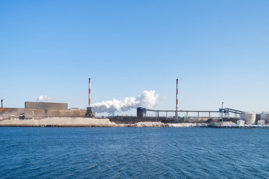 Heavy industrial steel plant with smoke emissions into the atmosphere. Metallurgical manufacturing process and environmental air pollution.