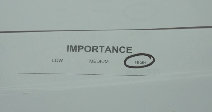 Close-up of an importance level scale with High circled. Concept for high importance, priority setting, critical decisions, task management and planning.