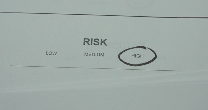 Close-up of a risk assessment scale with High circled. Concept for high risk, danger evaluation, risk management, safety assessment and decision making.
