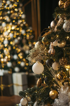 Christmas tree decorated with white and gold ornaments, glowing lights, and beautiful bokeh in the background.