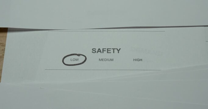 Close-up of a safety level scale with Low circled. Concept for low safety, security concerns, risk assessment, unsafe conditions and workplace safety evaluation.