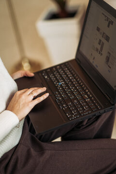 Woman hands typing on laptop keyboard working remotely or browsing online sitting at home.