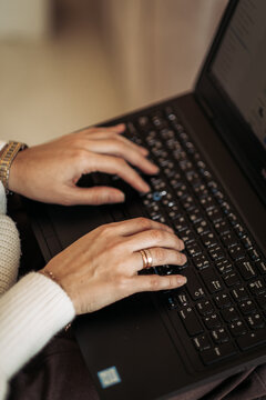 Woman hands typing on laptop keyboard working remotely or browsing online sitting at home.
