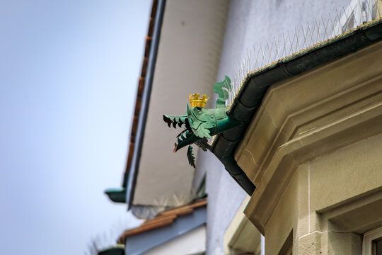 Green copper dragon gargoyle gutter spout on stone facade in Zurich, Switzerland