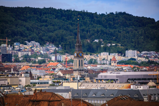 Historic St. Jakob church clock tower seen over rooftops in Zurich, Switzerland