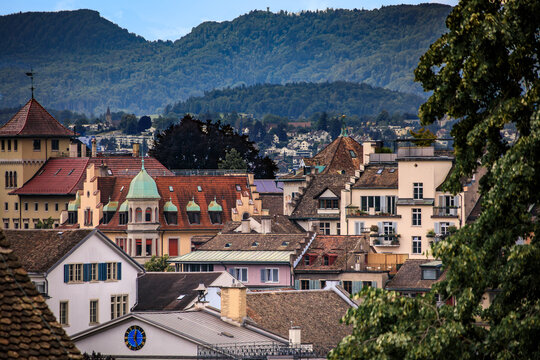 Tiled roofs with copper dormers against Uetliberg mountain in Zurich Switzerland