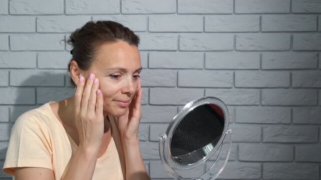Satisfied lady enjoy face with wrinkles. A woman with healthy face skin stand satisfied with her face skin at home