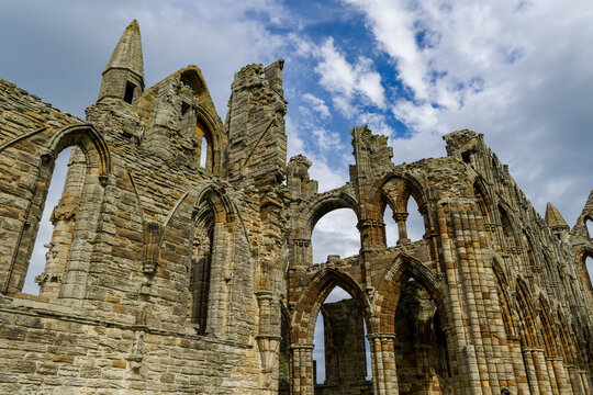 Ruined medieval abbey arches reaching toward open sky, eroded masonry and historic ecclesiastical architecture in northern England
