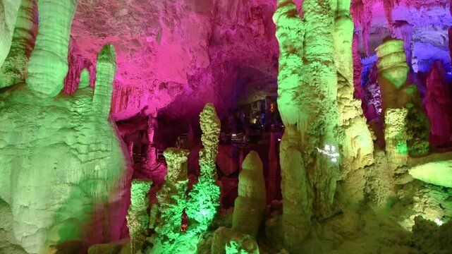 Colorful Illuminated Limestone Formations Inside a Large Underground Cave