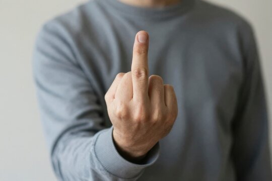 Obscene hand gesture of defiance and hostility, nonverbal communication expressing frustration, social rejection, provocation and anger, an outstretched middle finger directed squarely at the viewer as a metaphor for uncompromising conflict, visceral disdain and breakdown of civil discourse, isolated masculine hand against a muted grey long sleeve shirt emphasizing confrontation without personal identity, psychology of aggression and emotional venting in modern social interactions, raw rebellion against authority, behavioral psychology of insults, explicit boundary setting through offensive body language, tension between individual autonomy and societal norms, non verbal resistance, resentment, bitterness, anti social friction, direct anatomical gesture of refusal, AI-generated, AI generated
