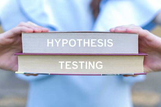 Concept of hypothesis testing. Girl holding two books sees the text HYPOTHESIS TESTING.