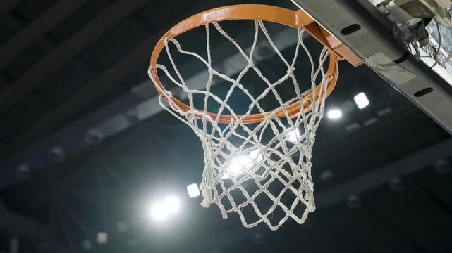 asketball player scoring a point as ball goes through hoop net in intense game action, Silhouette of basketball player jumping to dunk ball into hoop net on outdoor street court at sunset1