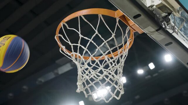 asketball player scoring a point as ball goes through hoop net in intense game action, Silhouette of basketball player jumping to dunk ball into hoop net on outdoor street court at sunset1