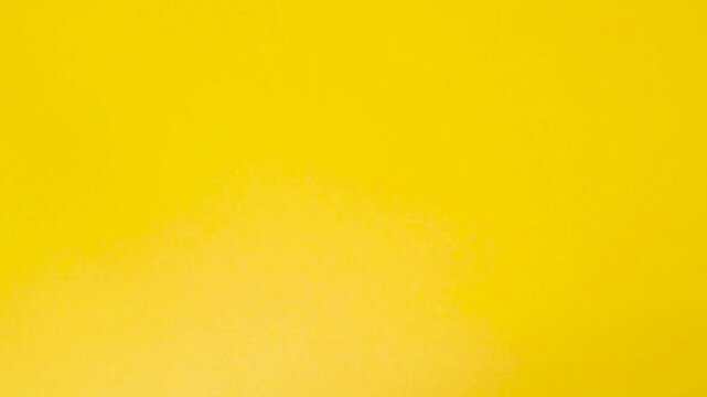 Red plastic letters on a yellow background. The word "love", the hand moves the letters, close-up, top view. The hand destroys the inscription love in Cyrillic.