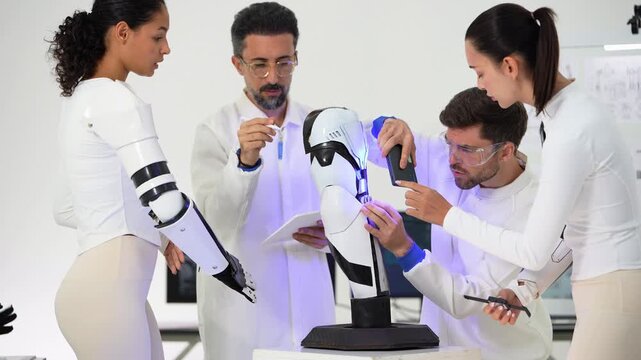 Woman wearing a robotic prosthetic arm stands beside a robot arm model as engineers in white lab coats examine it under blue UV light and check a tablet
