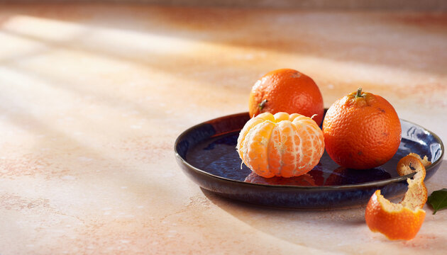 Fresh mandarins on a blue ceramic plate with copy space