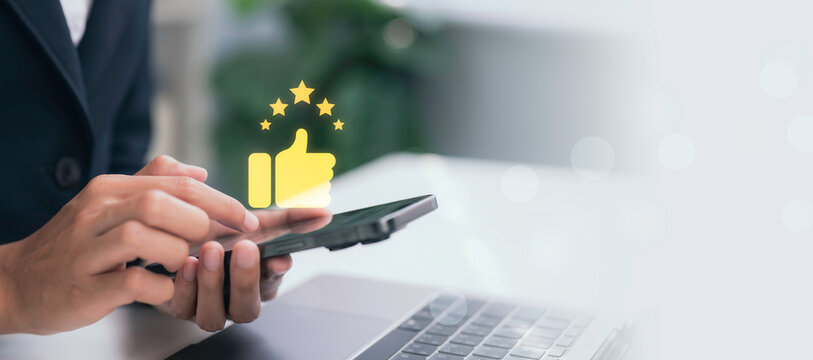 Digital customer engagement concept showing smartphone user interacting with positive rating icon, stars and thumbs up, representing satisfaction, online reviews, loyalty and brand reputation