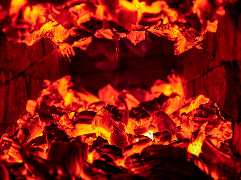 Bright burning hot firewood charcoal in a fireplace with glowing embers