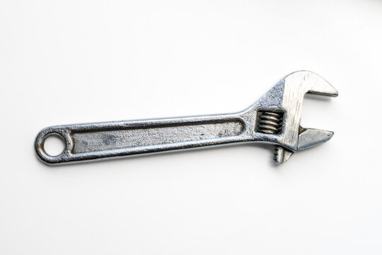 Adjustable metal wrench tool isolated on white background to illustrate mechanical repair work and garage construction tasks. Real Photo
