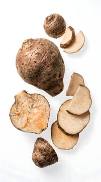Fresh whole and sliced taro root isolated on a white background.