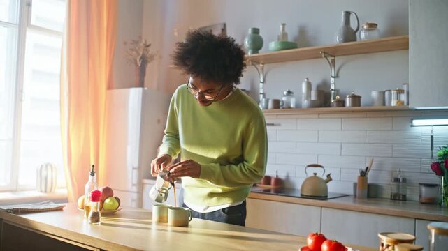 Boyfriend pouring coffee moka pot kitchen. Girlfriend feeding tomato breakfast.