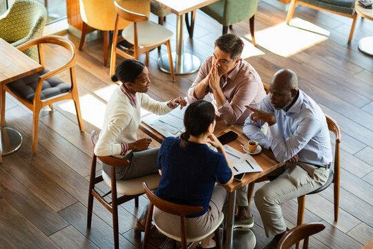 Coworkers discussing reports at a cafe table