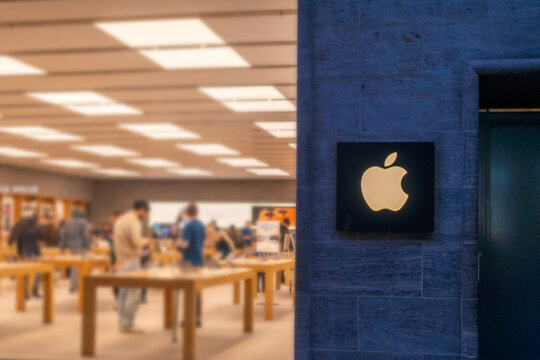 Apple logo on dark, retail store with customers, premium tech brand, urban electronics destination, Sales Office, electronics brand, blurred interior retail space, storefront Hannover, Germany