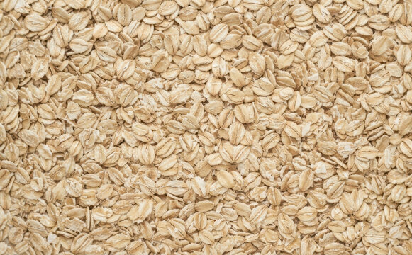Rolled oats background texture close up, healthy breakfast food ingredient concept for baking and cooking preparation