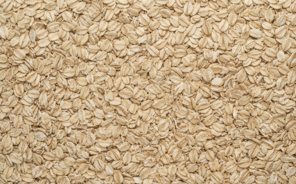 Rolled oats organic texture background closeup top view, healthy breakfast food ingredient wallpaper and dietary fiber grain pattern