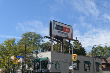 Fototapeta premium wide view of a rooftop billboard advertising Crave/TSN online streaming services, atop Starbucks Coffee Company shop at 694 Mount Pleasant Road, Toronto