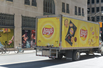 Fototapeta premium Lay's snack food delivery vehicle heading south on Bay St in downtown Toronto