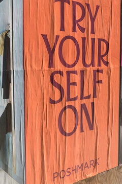 orange text-based wheatpaste poster by Poshmark, a social commerce platform for buying and selling fashion items, in Toronto ("Try Your Self On")