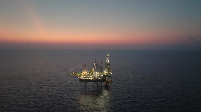 Offshore drilling rig - jack up and offshore platform during sunset for oil and gas exploration and production. 