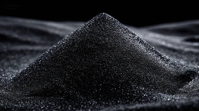 A mound of fine ebony wood dust creating a dark powder texture on a surface