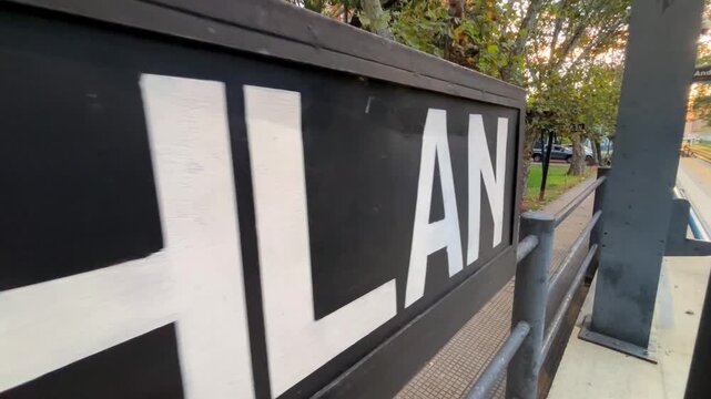 Close-up lateral shot of the old wooden sign at Coghlan train station along the platform in Buenos Aires, Argentina.